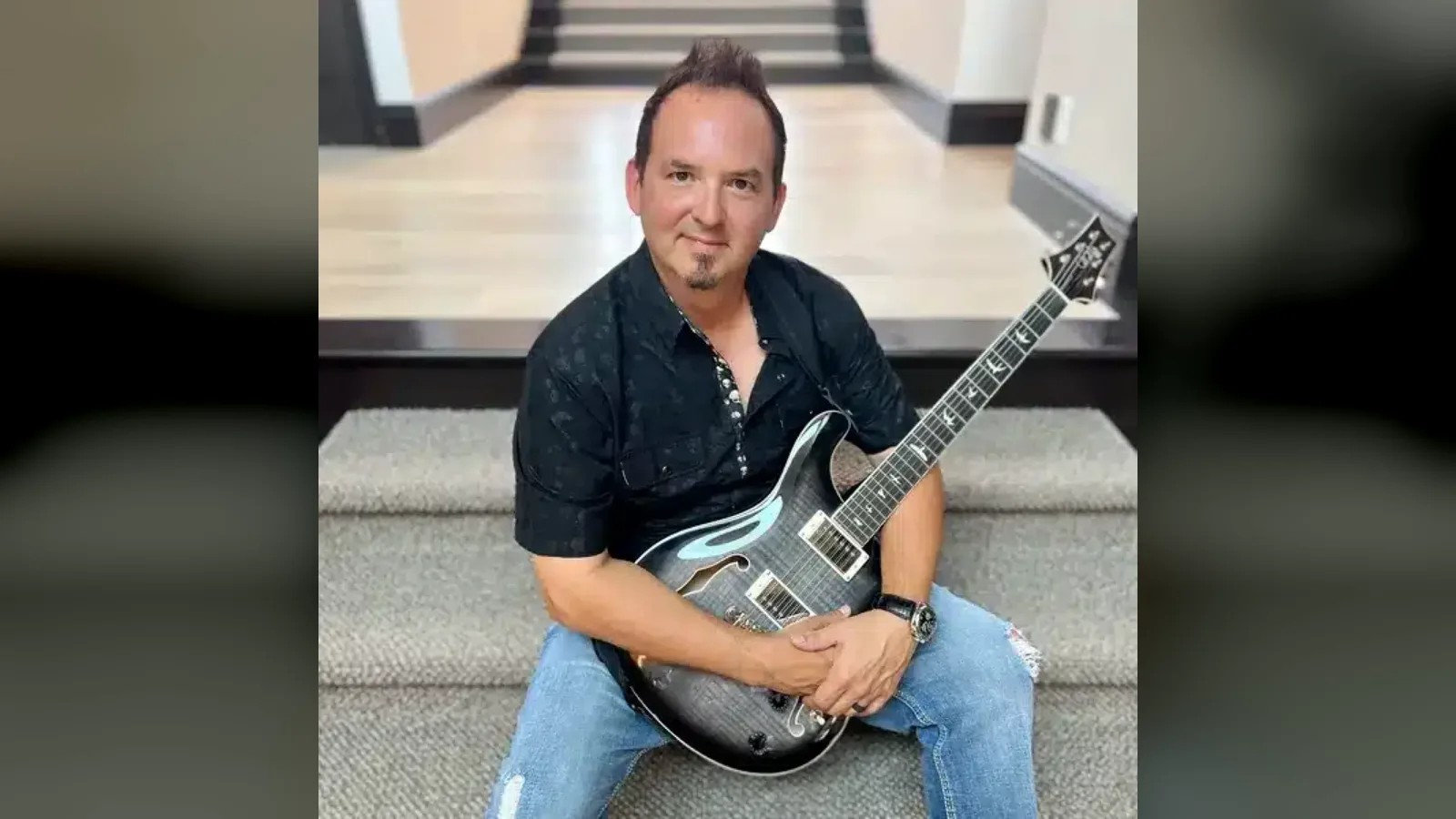Adam DeGraide with a guitar
